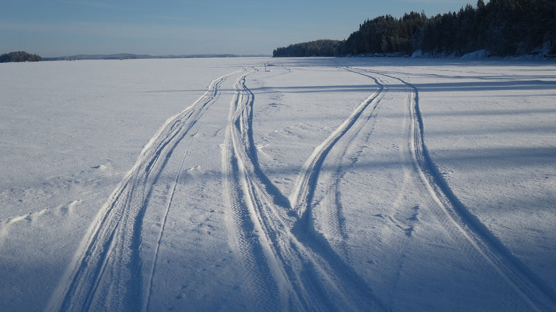 Ice fishing on a frozen Nordic lake — the setup where an underwater fishing camera dropped through the hole earns its place